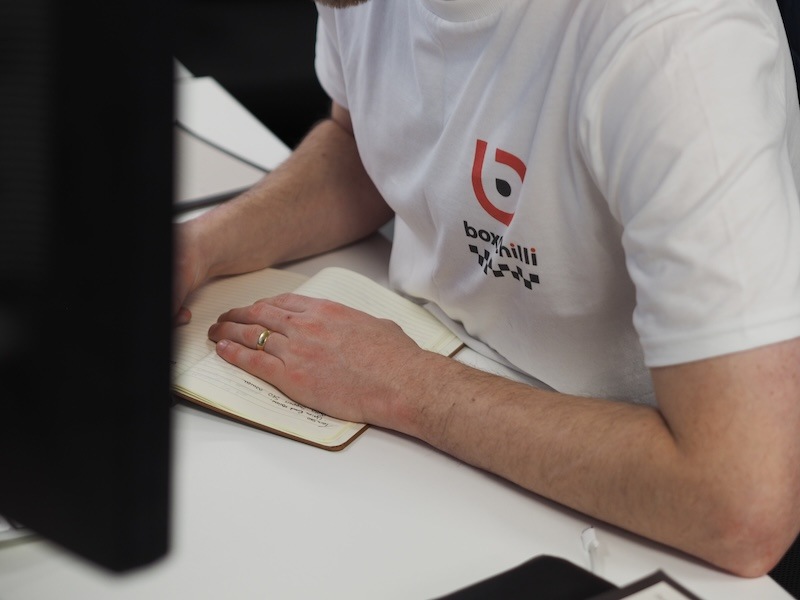 man working at desk in a white boxchili branded t-shirt